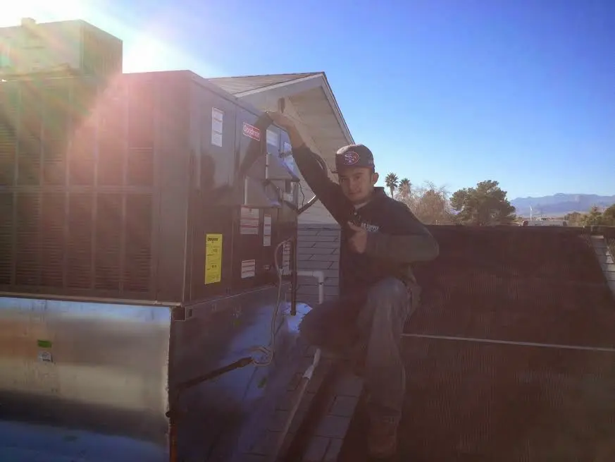 HVAC technician performing HVAC Inspection on a rooftop unit in Moab